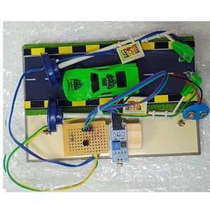 GO Science Smart Street Light Classroom Concept Model Kit inside box go science classroom series. A toy car racing circuit board kit featuring a green plastic toy car, a printed race track, a breadboard, a potentiometer, and various connecting wires on a beige circuit board base.