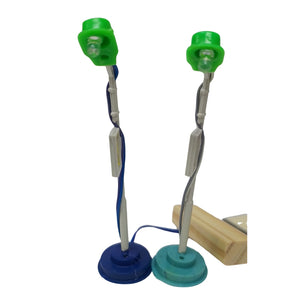 Two small desk-style lamps with green plastic heads, twisted metal stems, and round bases in blue and teal, shown on a white background with a small wooden block supporting one base.