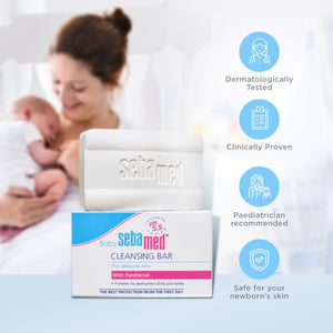 Sebamed baby cleansing bar with packaging and a mother holding a baby on a light background