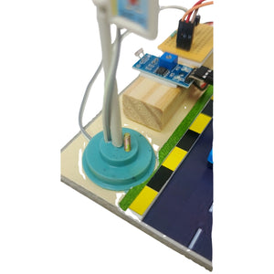 Smart Street Light school project go science classroom series product image model 3. A small electronic circuit board setup on a wooden base with a blue circular base, white pole, yellow platform, and black-and-yellow striping, photographed against a white background.