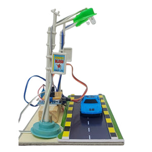 Smart Street Light school project go science classroom series product image model 4. A miniature toy traffic light and car assembly on a white background. The model features a gray plastic pole with a green traffic light, a blue toy car on a road, and various wiring and base details.