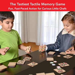 Two children playing a memory game with food-themed cards on a table.