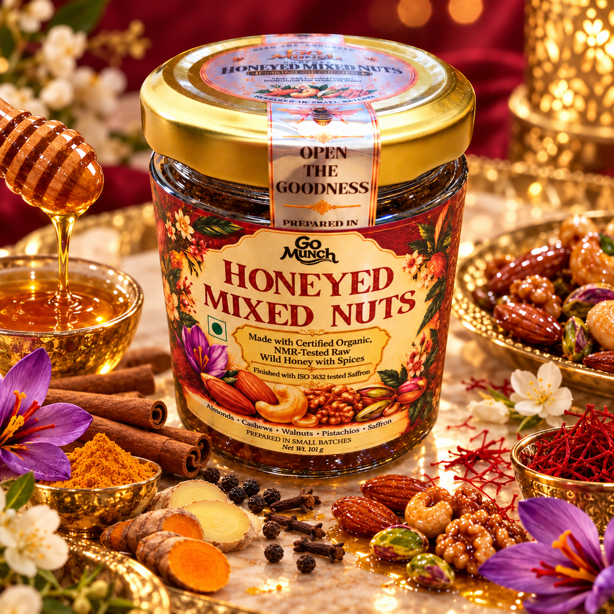 A jar of Go Munch by Go Science Honey Mixed Nuts is beautifully styled on a marble surface with a golden honeycomb lid, surrounded by nuts, cinnamon, turmeric, and a dripping honey dipper.