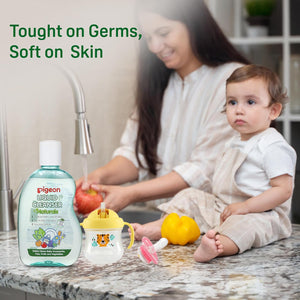Woman washing fruits with a baby and Pigeon liquid cleanser on a kitchen counter. Pigeon Liquid Cleanser Bottle Naturals 200ml go littles product image 7