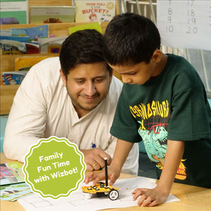 Man and child working on a project together with a Wizbot toy, surrounded by educational materials. Stempedia Wizbot Maxx Jungle Safari – Screen-Free STEM Robot Toy for Kids Age 4+ image 5 available at go science 