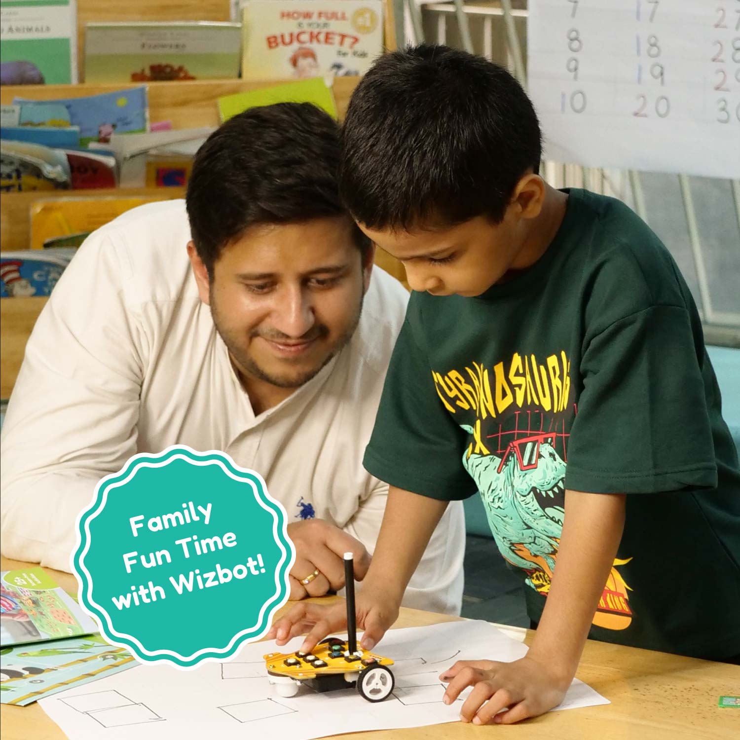 Man and child engaged in an activity with a Wizbot toy, surrounded by educational materials. Stempedia Wizbot Parent-and-kid-activities-with-Wizbot-Maxx-1 available at go science